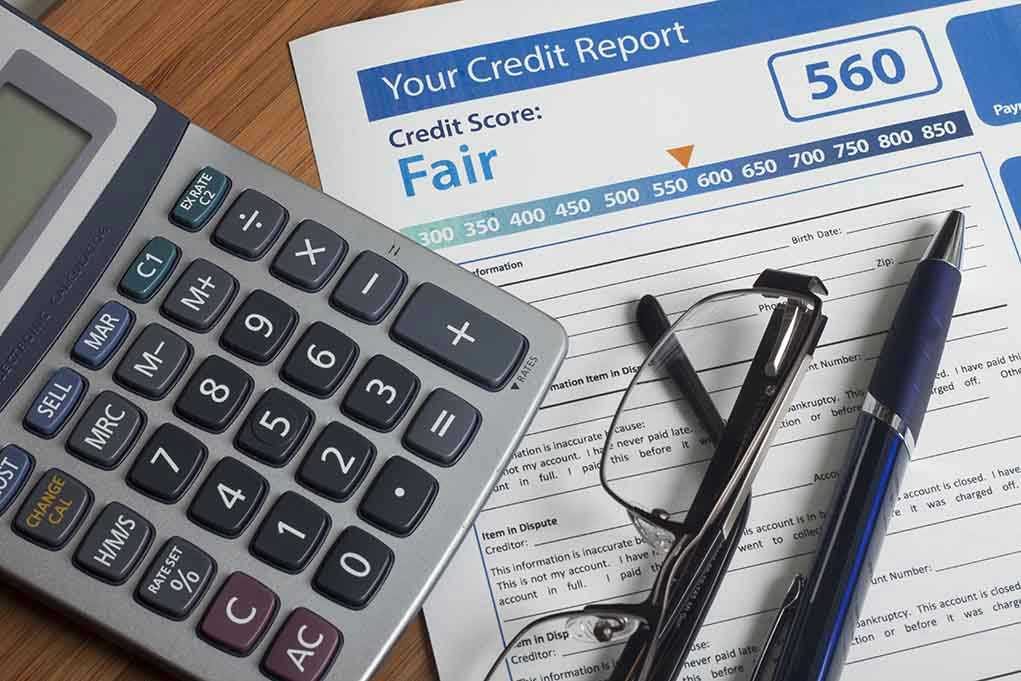 243901528 Calculator and glasses on credit report document
