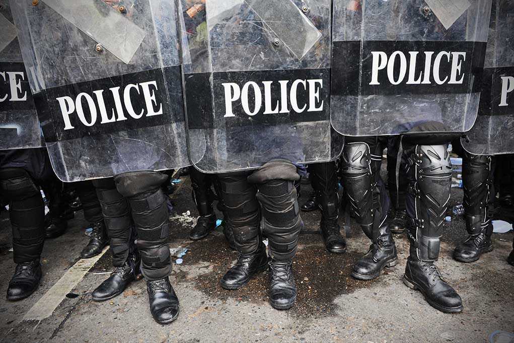208336891 Police officers in riot gear holding shields