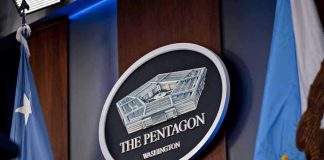 The Pentagon emblem between two flags