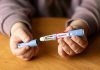 GLP-1 Drug Horror: 10 Deaths Raise Alarms Hands holding an Ozempic injection pen.