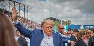 Person in blue suit waving at outdoor event