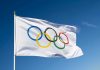 IOC Set to Abandon Transgender Policy Olympic flag waving against clear blue sky.
