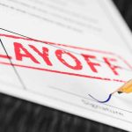 Close up of a layoff notice with a signature line and a fountain pen