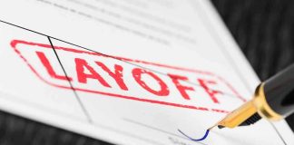 Close up of a layoff notice with a signature line and a fountain pen