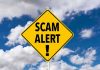 Nationwide AI-Text Toll Scam – Beware Yellow warning sign displaying 'SCAM ALERT!' against a cloudy blue sky