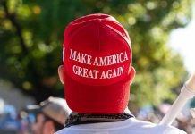 MAGA Civil War Erupts Behind Scenes Person wearing a red Make America Great Again hat.