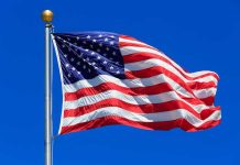 Racial Justice Data Sparks Major Debate Waving American flag against a clear blue sky