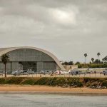 Aircraft hangar with helicopters near the beach.
