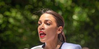 Person speaking into multiple microphones outdoors.