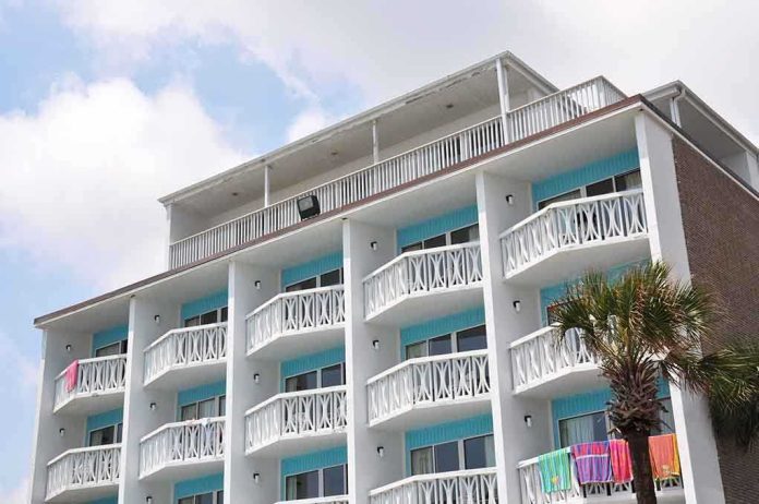 Exterior view of a beachfront hotel with balconies and colorful towels hanging