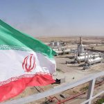 Iranian flag near an industrial gas refinery.