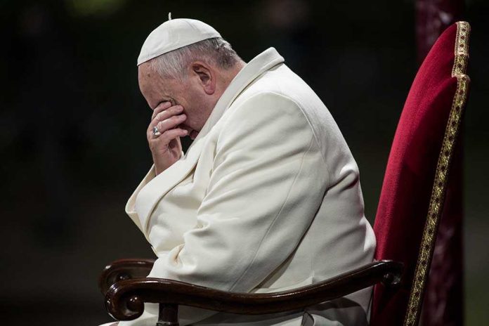 shutterstock_188022557.jpg Pope sitting with his head bowed and hand covering his face