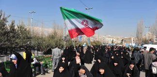 Iran’s Risky Strategy: Children as Shields Group of women in black attire marching with an Iranian flag