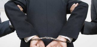 Ohio Surgeon SHOCKER: Forced Abortion Pills Crime Person handcuffed in suit, escorted by two others.
