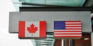 Trump’s Bold Move: Canada’s Defense Board FROZEN! Canadian and American flags displayed at a border crossing