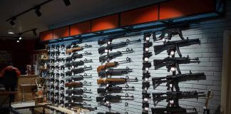 Assault Ban Sparks Virginia Buyout Frenzy Wall display of various rifles in a gun store.