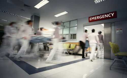 Medical staff rushing patient on stretcher in emergency room.