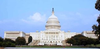 Capitol Breach Convict Gets Pentagon Security Role View of the U.S. Capitol building with a security barrier in front