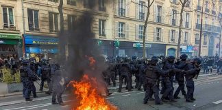 Three Suspects Held After Coordinated Firebomb Attacks Fire burning on the street amid police presence.