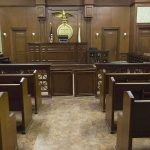 The Alibi Collapsed And So The Murder Defense Interior view of an empty courtroom with wooden benches and a judges bench