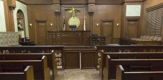 The Alibi Collapsed And So The Murder Defense Interior view of an empty courtroom with wooden benches and a judges bench