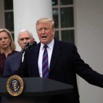 Trump Escalates: “We’ll Hit Iran Hard Again” man speaking at podium with officials standing behind
