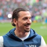 World Cup Chaos Erupts After Spain Win smiling man with tied-back hair at a sports stadium