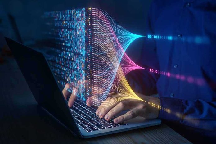 shutterstock_2284126663 Hands typing on a laptop with colorful data streams visualized