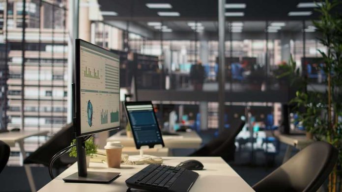shutterstock_2632499253 Computer monitor with analytics dashboard in a modern open office