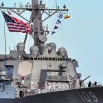 U.S. Navy Unveils AI War Strategy A naval destroyer displaying the American flag and various signal flags