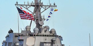 U.S. Navy Unveils AI War Strategy A naval destroyer displaying the American flag and various signal flags