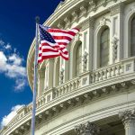 American flag waving before a neoclassical government building