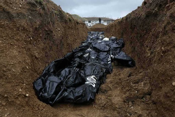 shutterstock_1614227278 Body bags in a mass grave trench