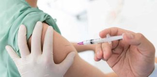 Healthcare worker giving an intramuscular injection in upper arm