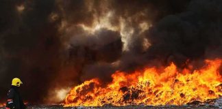 Explosion Rocks Italian Ammo Plant Supplying Ukraine Firefighter watches large blaze with thick black smoke