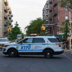 NYPD police SUV blocking a city street at a taped-off scene
