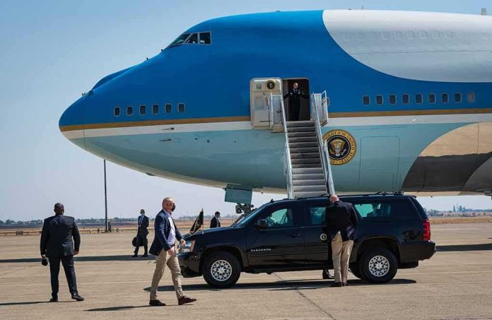 Security detail near blue and white aircraft with staircase and SUV