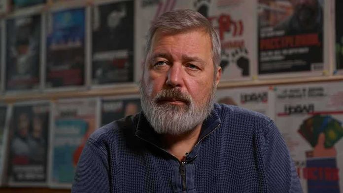 Bearded man in a blue sweater sitting indoors