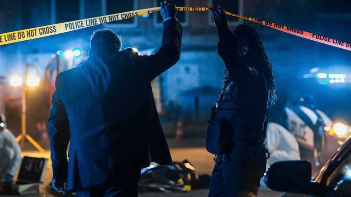 Investigators at night lifting police tape at a crime scene