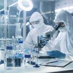 Michigan Reports First U.S. Deaths in Massive Parasite Outbreak Scientists in protective suits using a microscope in a laboratory