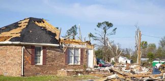 Built Too Wide, Now Facing the Bulldozer A severely damaged house with debris scattered around from a storm