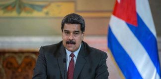 New Maduro Detention Photos Draw Attention Man speaking at podium with Cuban flag in background.