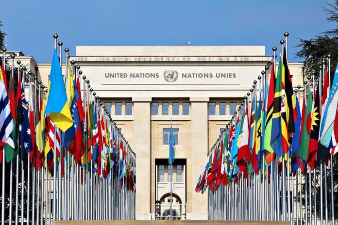 423802144-1 United Nations building with numerous national flags outside.