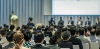 AI Development Faces New Calls for Pause Audience listening to a panel discussion in a conference hall
