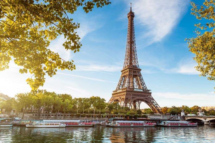 shutterstock_112137761-1 Eiffel Tower in Paris with boats on the river and green trees