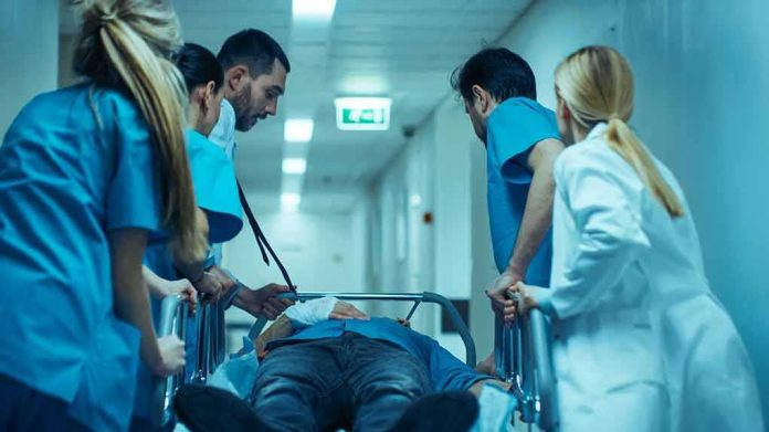 shutterstock_1189798267 Medical team rushing patient on a gurney through hospital corridor