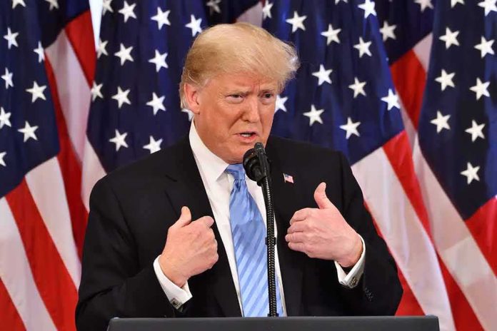 shutterstock_1200585187 Donald Trump speaking at a podium with American flags behind him