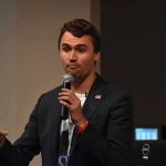 man speaking into a microphone during a talk