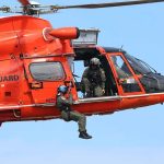 Rescue helicopter with crew performing hoist operation