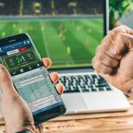 Person checking live soccer betting odds on a smartphone